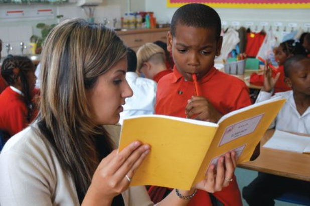 Teacher with student looking at book