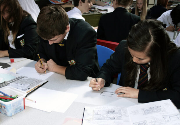 Children writing in work books in class.