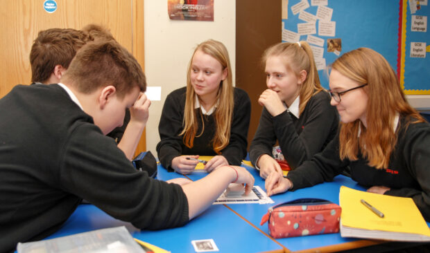 Group of secondary school pupils discussing something. 