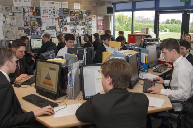 A classroom with pupils looking at graphs on computers. 