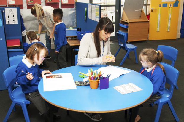 Children in an early years setting with a staff member.