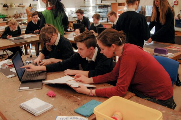 Teacher explains something to two pupils