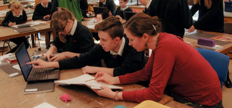 Teacher explains something to two pupils