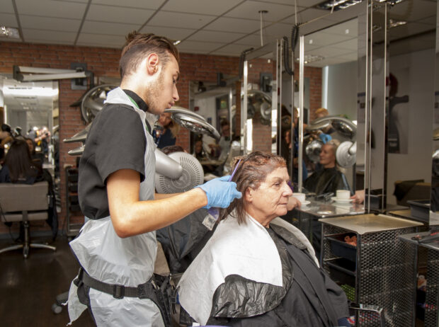 Apprentice hairdresser with a client.