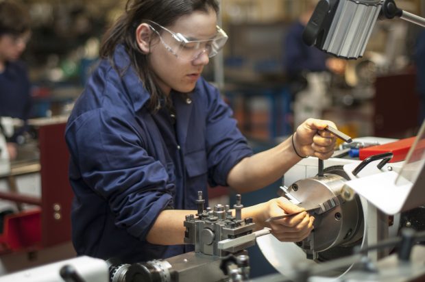 FEmale apprentice working with machinary