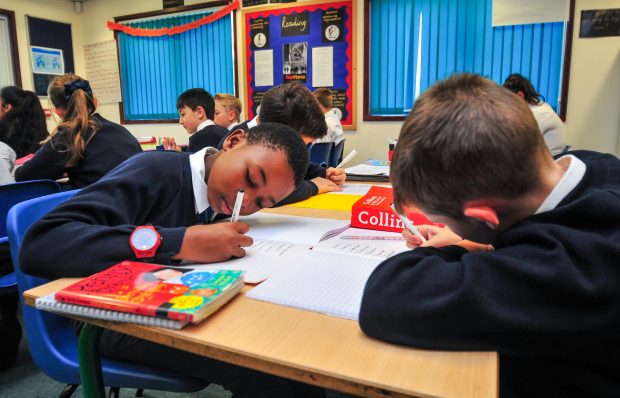 Primary school children writing in books