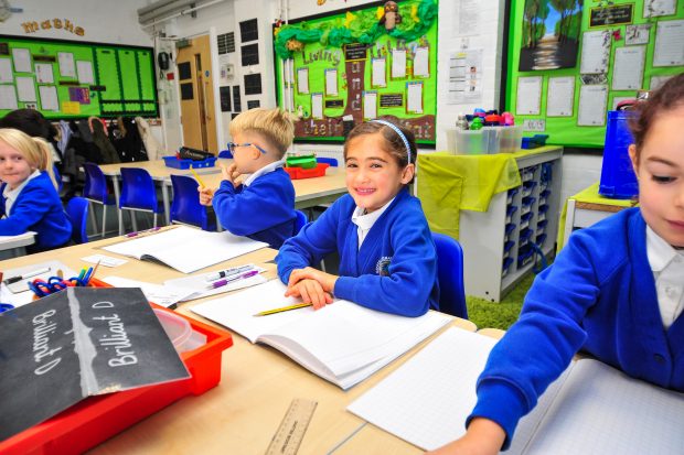 primary school children writing in workbooks