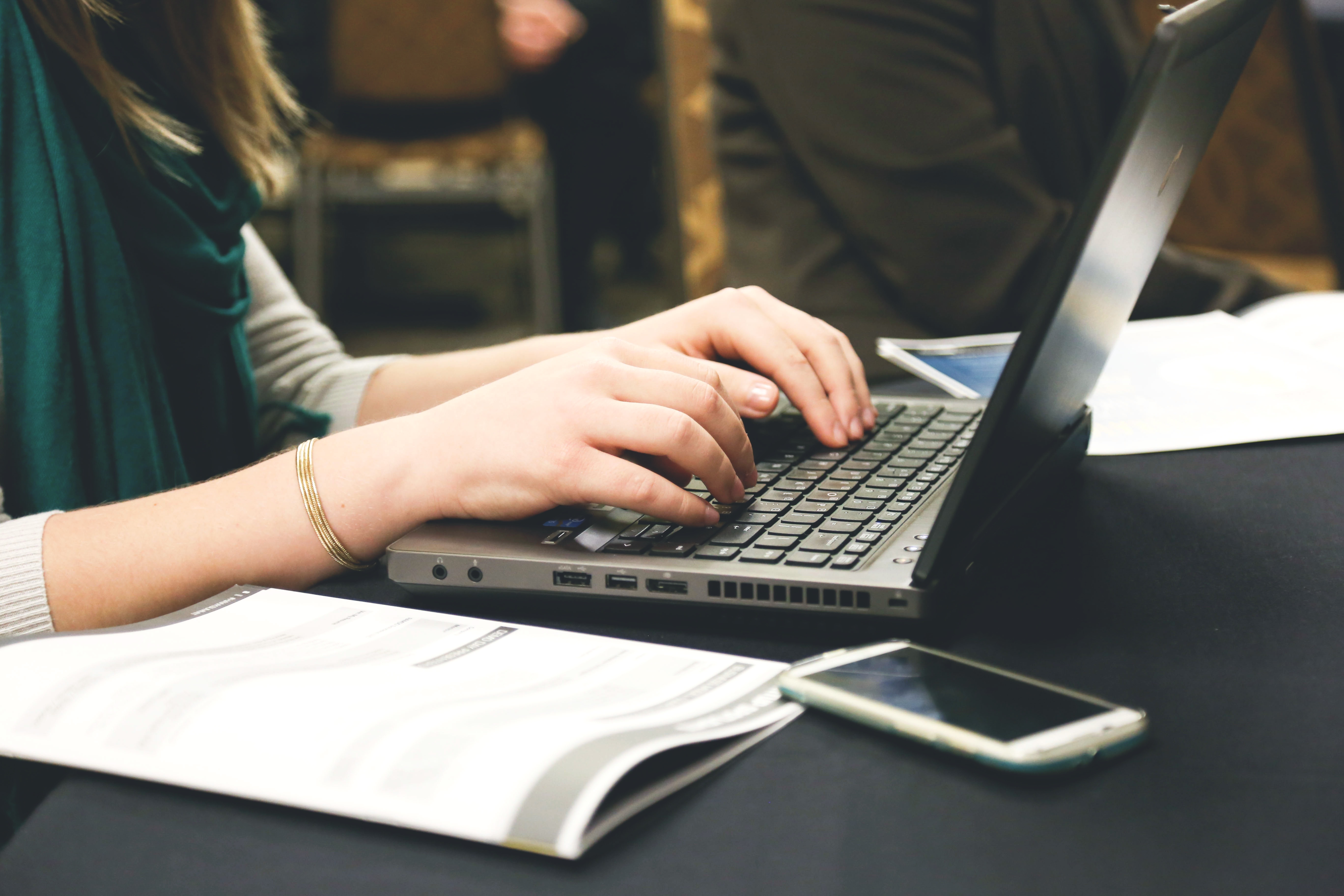 A woman using a laptop to type up notes